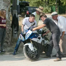 Štáb pomaly spúšťa motorku na zem, tak aby sa nepoškodila