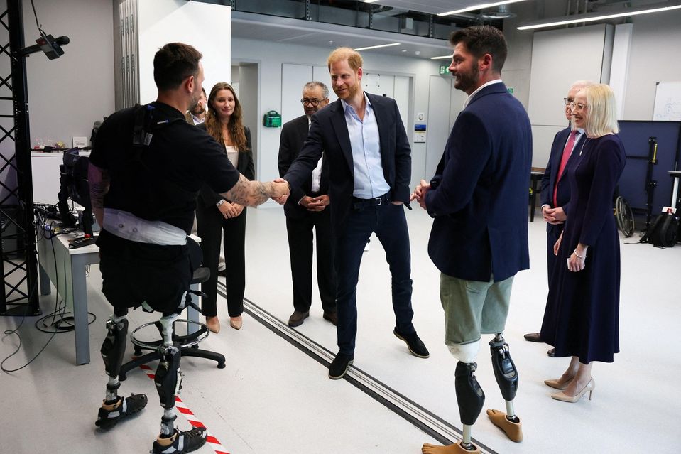 Vojvoda zo Sussexu (v strede) si podáva ruku so Stevom Arnoldom, ktorý súťažil na hrách Invictus, a s veľvyslancom Centra pre štúdium zranení Daveom Hensonom (vpravo v strede) počas návštevy Centra pre štúdium zranení spôsobených výbuchom na Imperial Coll