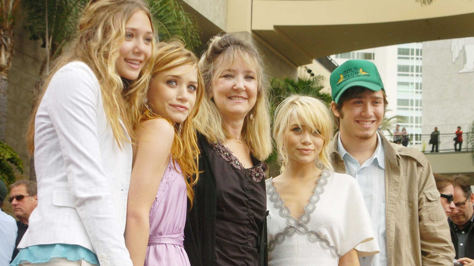 Mary-Kate (vľavo) a Ashley Olsen (vpravo) pózujú so sestrou Lizzie, mamou a bratom Trentom